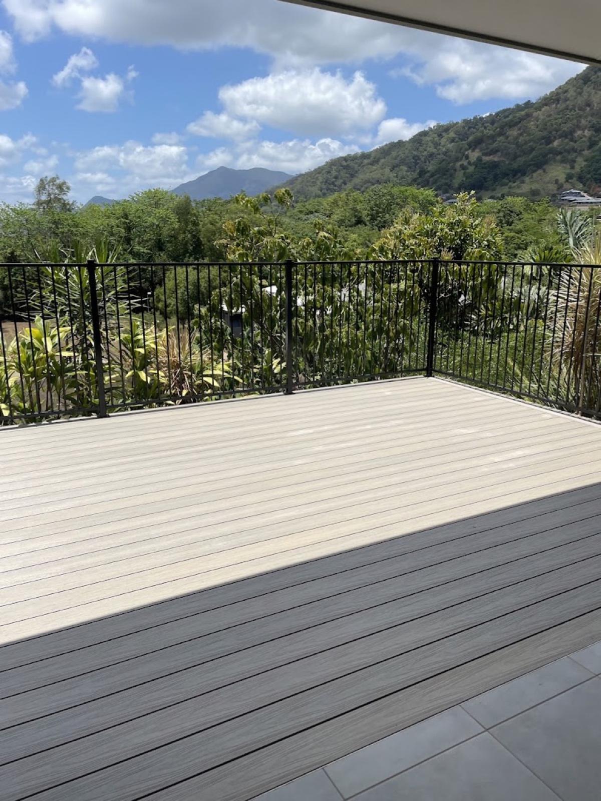 A composite deck with a black balustrade overlooking a green mountain range