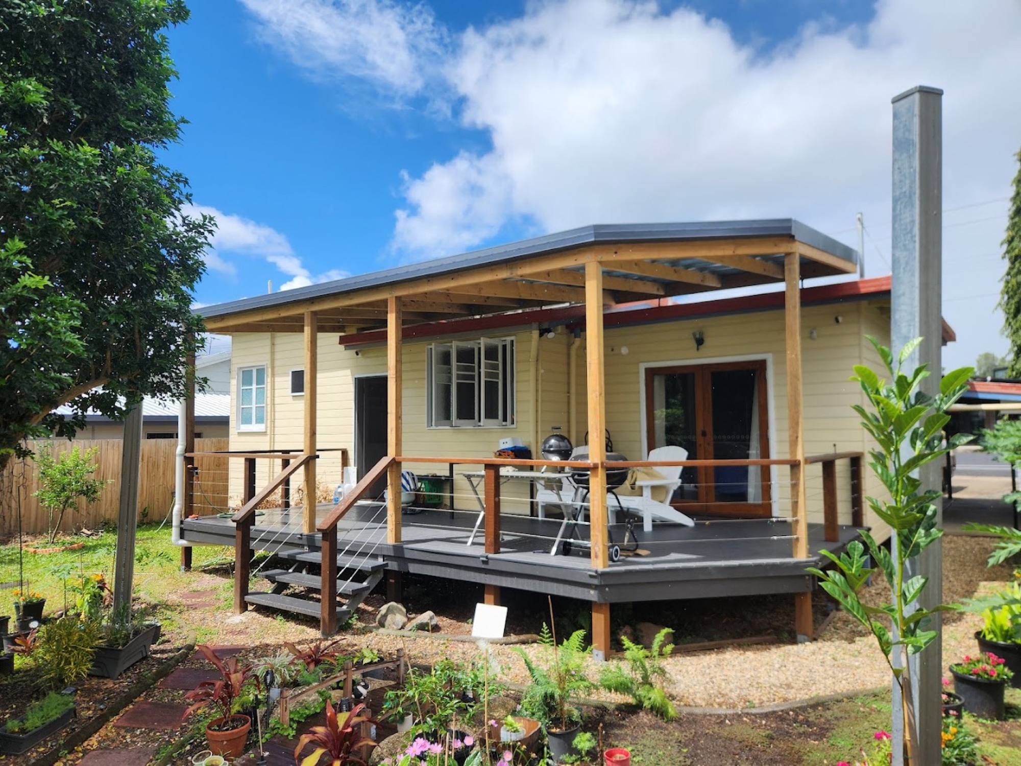 A weatherboard home with a new timber-framed patio roof and a deck along the front
