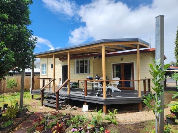 A weatherboard home with a new timber-framed patio roof and a deck along the front