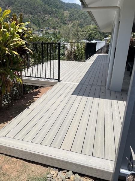 A composite deck wrapping the corner of a house above a garden bed