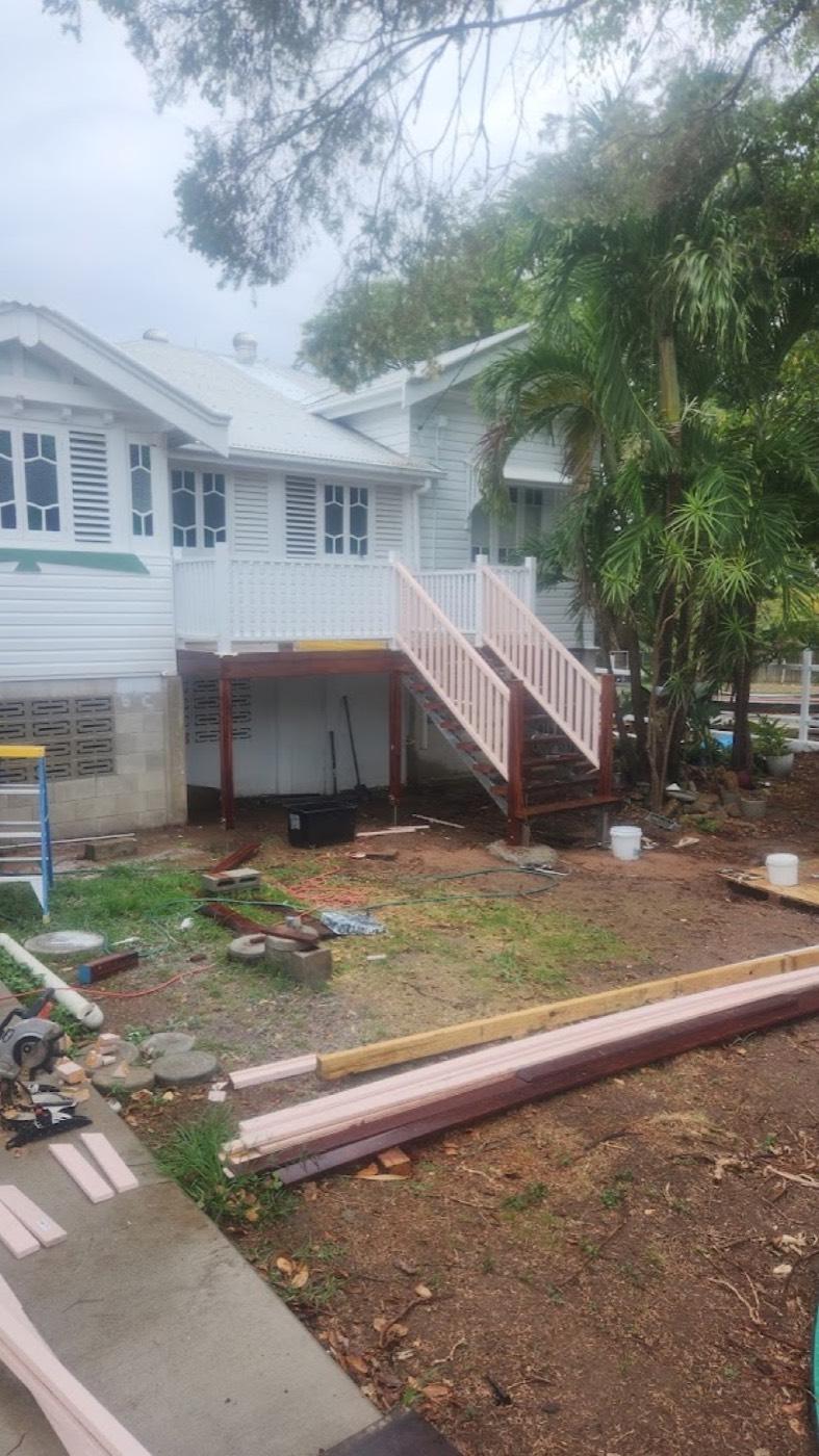 A white timber balustrade and staircase on a raised weatherboard home